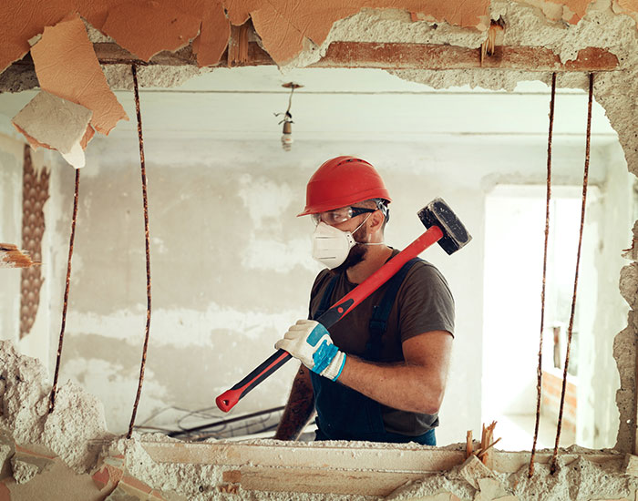 Worker with mask, hammer, and hardhat in Peterborough Canada
