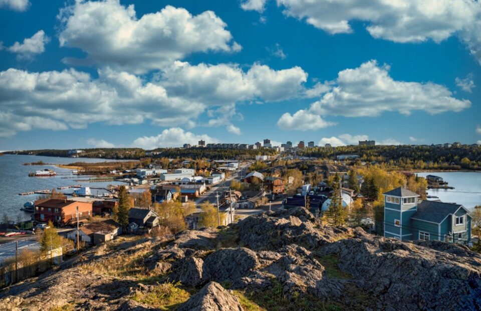 A view of colorful row houses & the harbor under a clear blue sky in Canada